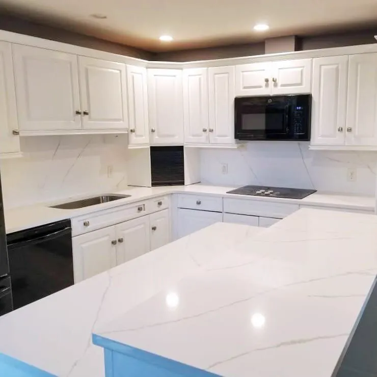 White quartz worktops along an L-shaped kitchen