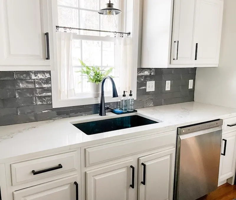 White quartz worktop with an undermount sink and grey tiles