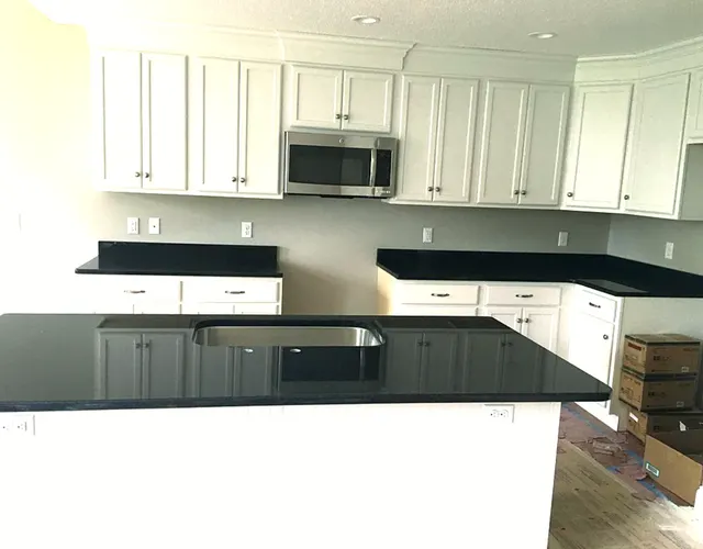 Black quartz worktops in a white kitchen